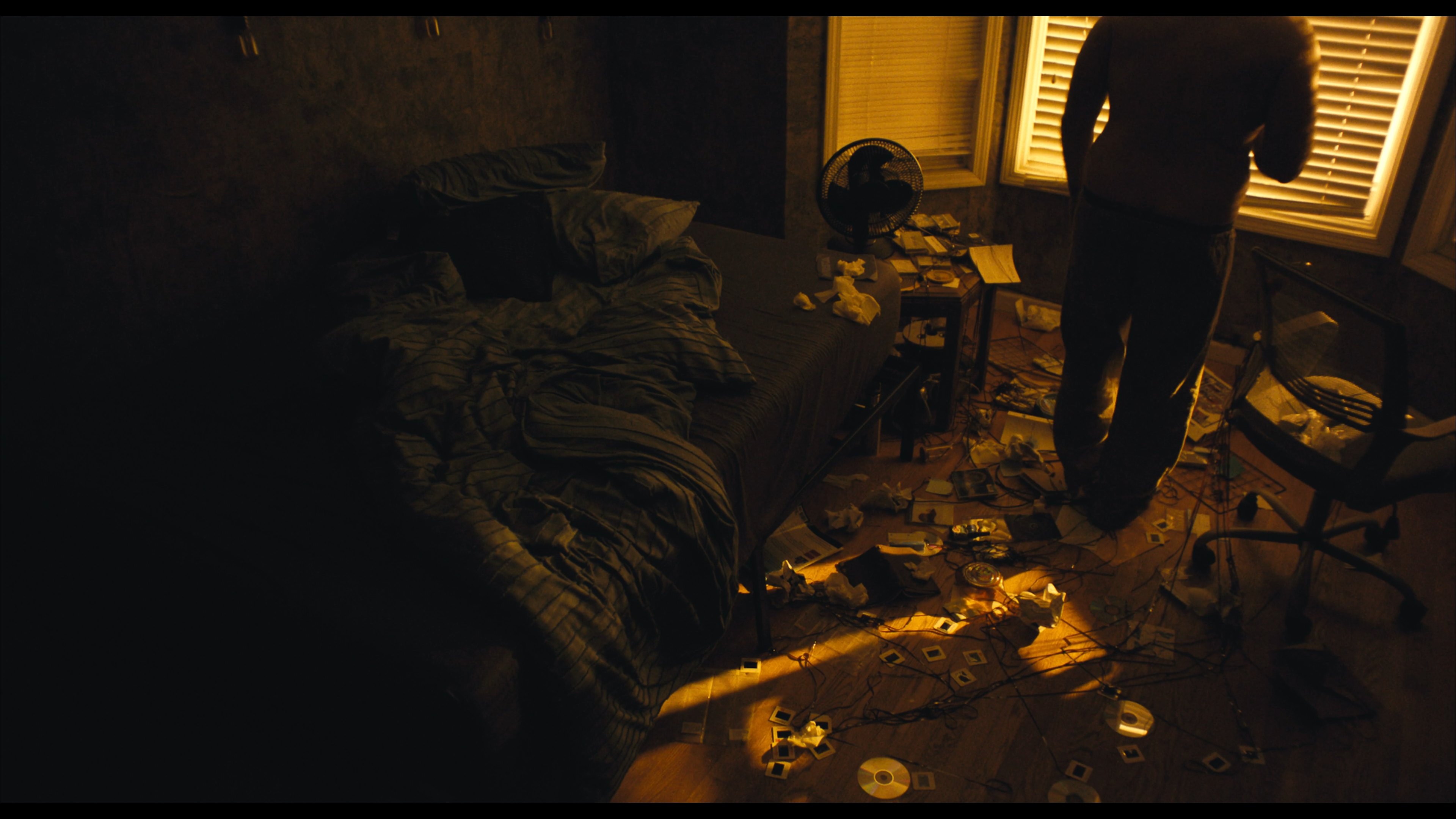 A disordered bedroom lit in amber