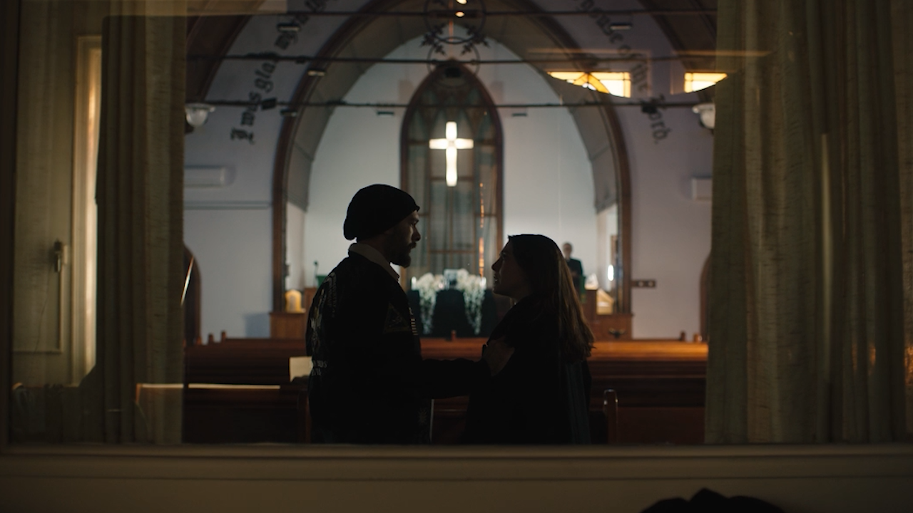 Two characters standing inside a church
