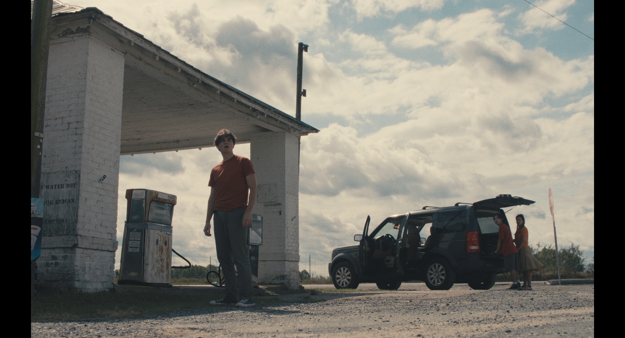 A character beside an abandoned gas station in Happy Land