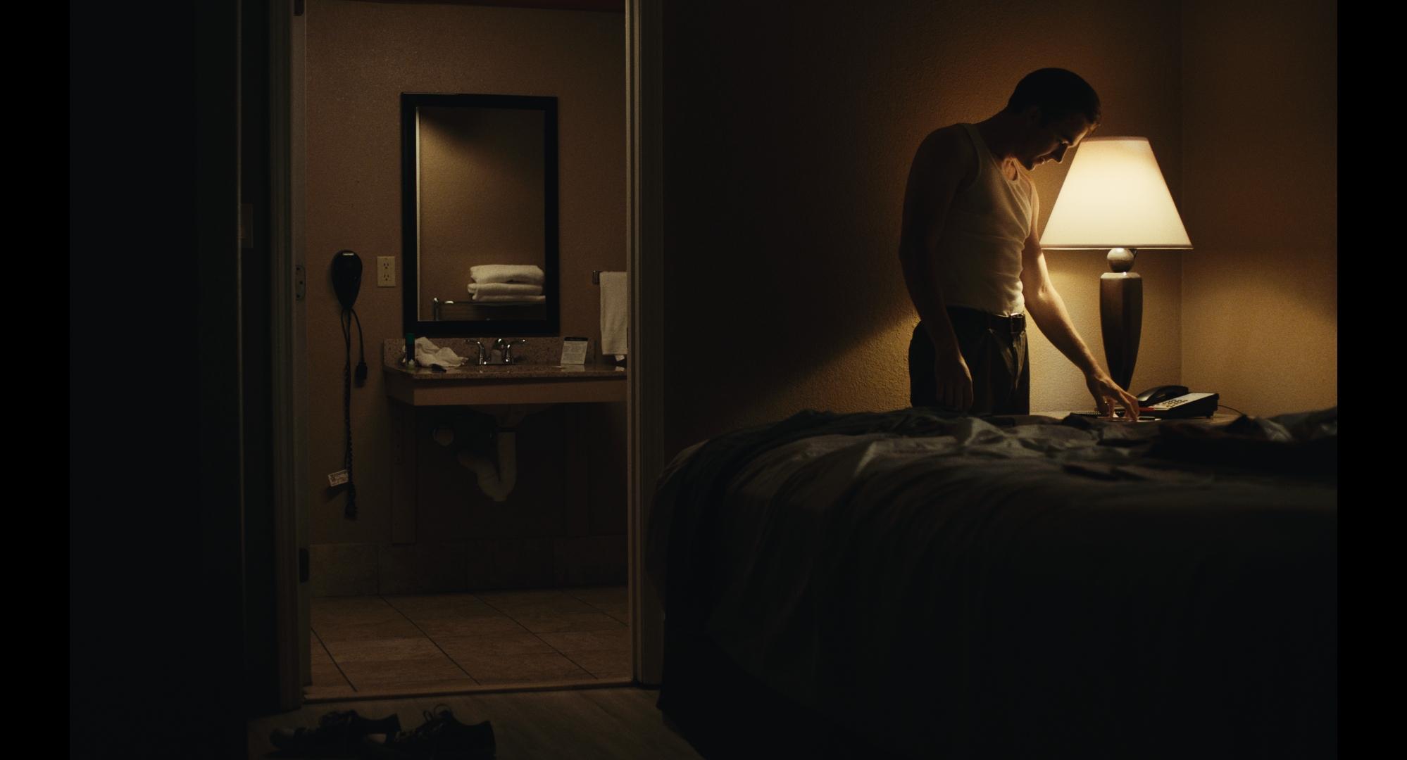 A character beside a lamp in a motel room